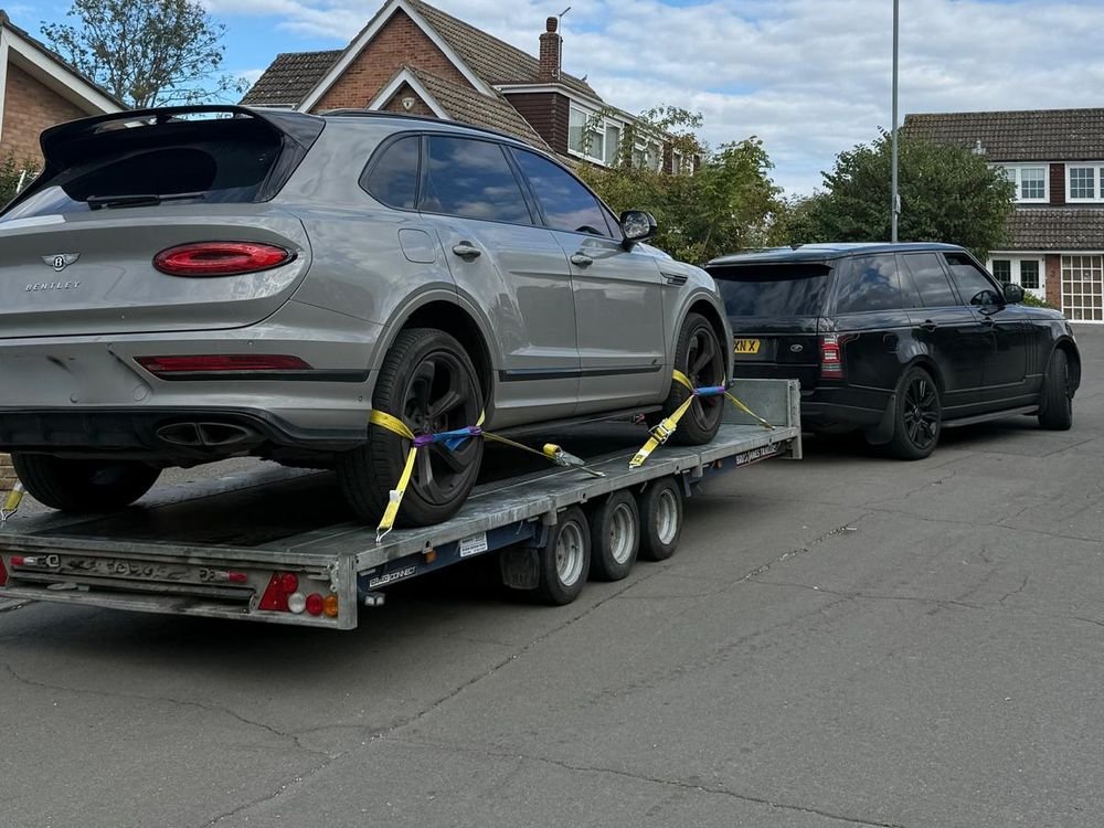 Bentley Bentayga secured on a car trailer on a residential road